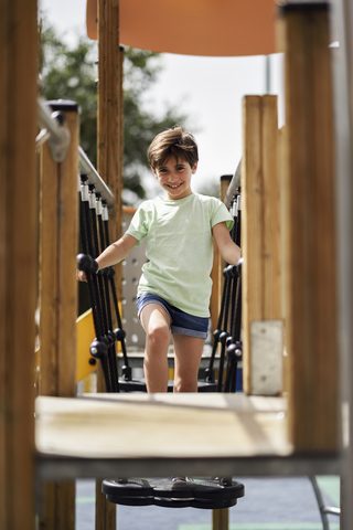 Porträt eines lächelnden kleinen Mädchens, das Spaß auf einem Spielplatz hat, lizenzfreies Stockfoto