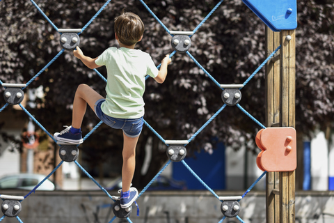 Back view of little girl on climbing frame stock photo