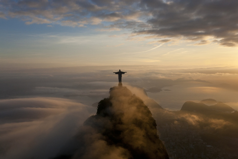 Blick von oben auf die kolossale Christus-Erlöser-Statue, umgeben von Wolken in der Abenddämmerung, Corcovado, Rio de Janeiro, Brasilien., lizenzfreies Stockfoto