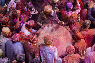 Hochformatige Ansicht von Menschenmassen, die sich beim Holi, einem hinduistischen Frühlingsfest, in Farbe hüllen. - MINF06578