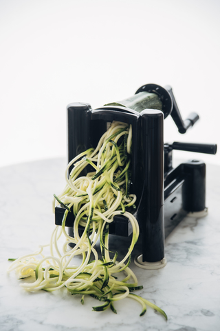 Herstellung von Zucchini-Nudeln, Zoodles, Spiralgemüseschneider, lizenzfreies Stockfoto