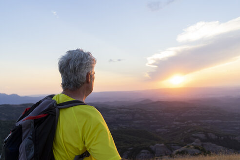 Spanien, Katalonien, Montcau, älterer Mann mit Blick auf die Aussicht von der Spitze des Hügels bei Sonnenuntergang - AFVF01354