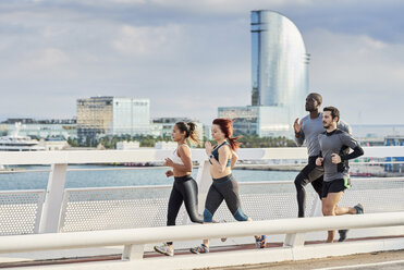 Gruppe von Sportlern beim Joggen am Hafen - JNDF00030