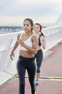 Female athletes running on a bridge - JNDF00032