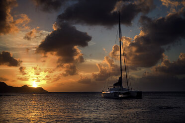 Segelboot auf dem Meer unter bewölktem Himmel bei Sonnenuntergang. - MINF06646