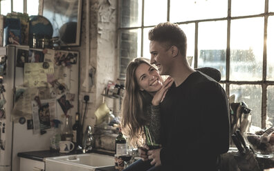 Smiling young woman and young man standing indoors by a window. - MINF06708