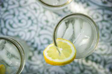 Draußen im Sommer. Limonade machen. Overhead-Aufnahme von Limonadengläsern mit einer frischen Zitronenscheibe am Glasrand. Bio-Limonadengetränke. - MINF06745