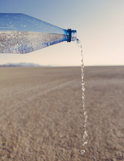 Die Landschaft der Black Rock Desert in Nevada. Ein überlebenswichtiges Element. Eine Flasche Wasser wird ausgegossen. Gefiltertes Mineralwasser. - MINF06751
