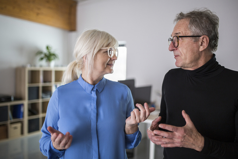 Two senior colleagues discussing in office stock photo