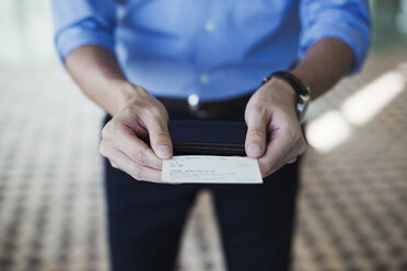 Close up of man standing in subway station, holding ticket, Tokyo commuter. - MINF06866