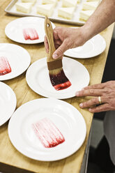 Chef hands preparing a desert plate. - MINF06905