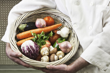 Chef holding a basket of freshly picked vegetables. - MINF06909