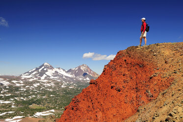 Ein Wanderer genießt die Aussicht auf eine Bergkette. - AURF00003