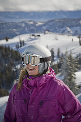 Eine Skifahrerin mit Helm lächelt und hat Spaß auf der Skipiste. - AURF00008