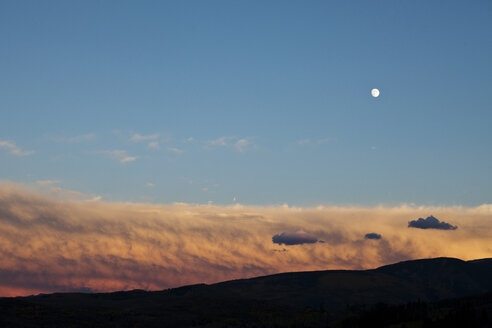 Bei Sonnenuntergang geht der Vollmond über feurigen Wolken auf. - AURF00028