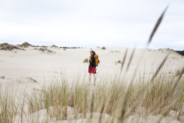 Ein Mädchen läuft allein mit einem Rucksack durch die Sanddünen. - AURF00029