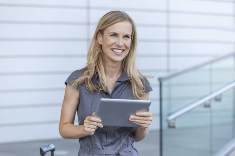 Lächelnde blonde Geschäftsfrau mit Tablet, lizenzfreies Stockfoto
