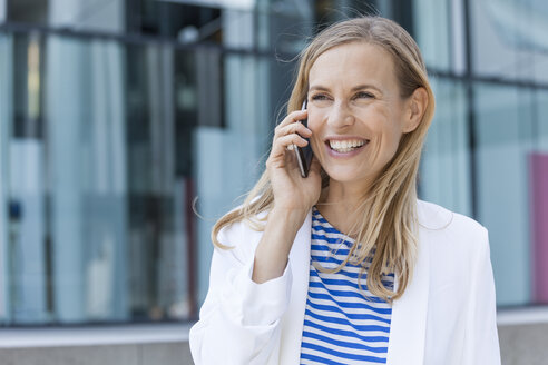 Smiling blond businesswoman using smartphone - TCF05536