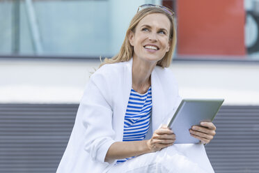Lächelnde blonde Geschäftsfrau mit Tablet - TCF05540