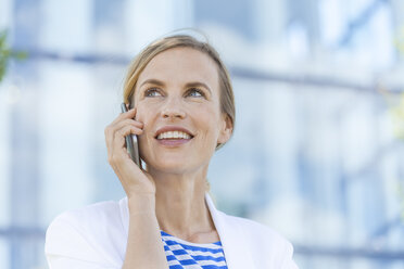 Lächelnde blonde Geschäftsfrau mit Smartphone - TCF05551