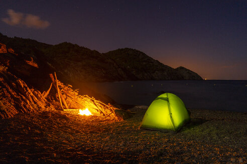 Spanien, Katalonien, Costa Brava, grünes Zelt und Lagerfeuer bei Nacht - AFVF01375