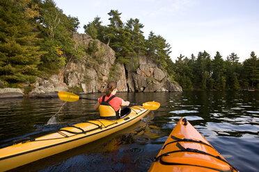 Junge Frau beim Seekajakfahren auf dem Muskoka River, Muskoka, Ontario, Kanada. - AURF00041