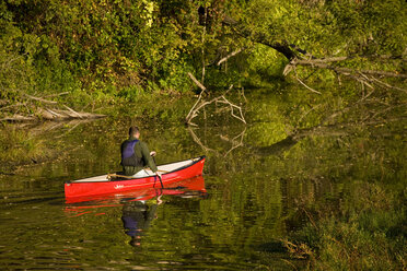 Junger Mann beim Kanufahren im Solokanu auf dem Farmington River, Collinsville, Connecticut, USA - AURF00042