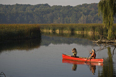 Junges Paar paddelt mit dem Kanu auf einem kleinen Bach in der Nähe der Irondequoit Bay, Rochester, New York, USA. - AURF00048