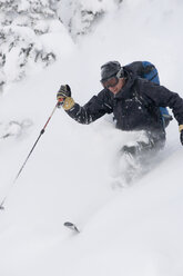 Junger Mann beim Skifahren im Tiefschnee - AURF00077