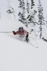 Junger Mann beim Skifahren im Tiefschnee - AURF00079