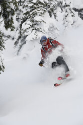 Junger Mann beim Skifahren im Tiefschnee - AURF00080