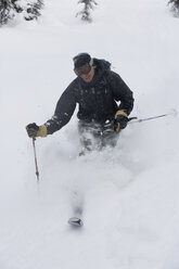 Junger Mann beim Skifahren im Tiefschnee - AURF00081
