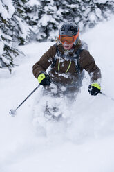 Junge Frau beim Skifahren im Tiefschnee - AURF00089