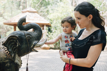 Thailand, Chiang Mai, Frau und Kind bewundern die Statue eines Elefanten im buddhistischen Tempel Wat Pha Lat - GEMF02272