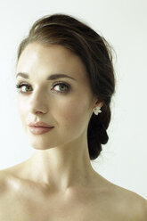 Portrait of a woman with brown hair tied in an elegant bun. - MINF06954