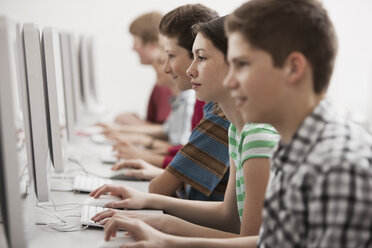 Eine Gruppe junger Menschen, Jungen und Mädchen, die in einem Computerkurs an Bildschirmen arbeiten. - MINF06995