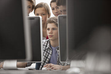 A group of young people, boys and girls, working at computer screens in class. - MINF07004