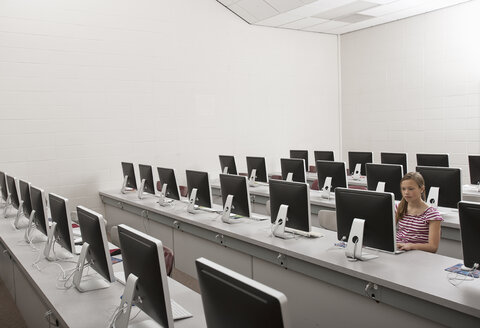 Ein Schulzimmer, ein Computerraum mit Reihen von Bildschirmen und Sitzgelegenheiten, ein Jugendlicher, der an einem Terminal sitzt. - MINF07009