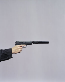 Detail eines Mannes, der mit einer Handfeuerwaffe mit Schalldämpfer zielt - MINF07069