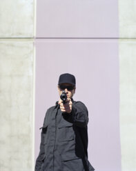 Mann in Spezialeinheiten, zielt auf eine scharfe Handfeuerwaffe mit angebrachtem Schalldämpfer - MINF07071