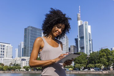 Deutschland, Frankfurt, lächelnde junge Frau mit Tablet in der Stadt - TCF05567