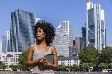 Germany, Frankfurt, portrait of young woman with tablet in the city - TCF05568