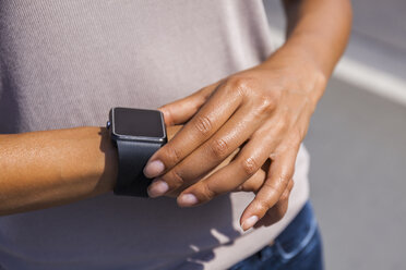 Woman's hand adjusting settings of smartwatch, close-up - TCF05572