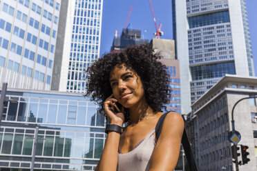 Deutschland, Frankfurt, Porträt einer lächelnden jungen Frau beim Telefonieren - TCF05580