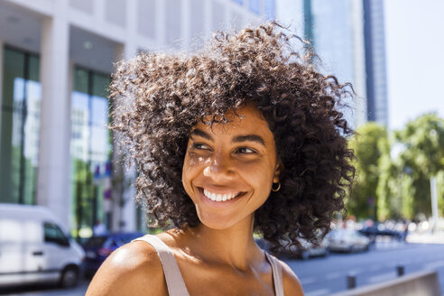 Germany, Frankfurt, portrait of laughing young woman with curly hair - TCF05603