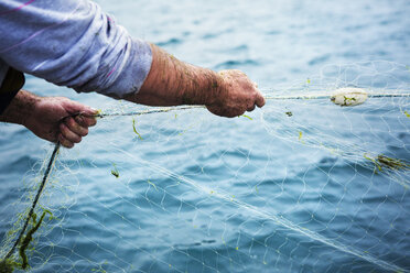 A fisherman pulling the net out of the water. stock photo