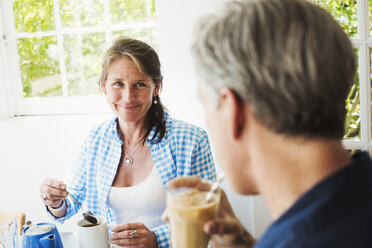 Eine Frau und ein Mann unterhalten sich bei einer Tasse Tee. - MINF07253