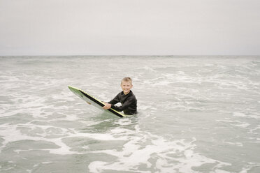 Blonder Junge beim Bodyboarden im Meer. - MINF07330