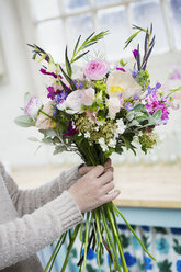 A florist creating a hand tied bunch of fresh flowers. - MINF07341