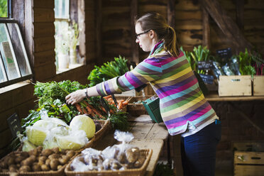 A woman handling produce in a farm shop. - MINF07372
